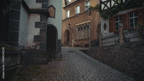 Narrow cobblestone street in Meißen old town, Germany, with historic facades, arched doorway and traditional architectural details creating a charming medieval atmosphere.