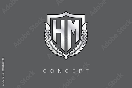 HM Creative Initial Letter Logo with Shield and Laurel Wreath Silver Metallic Branding Emblem on Gray Background.