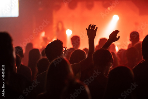 Fotografía Man in Glasses Worshipping Under Orange Stage Lighting