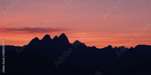 An ethereal blend of orange and red sunlight illuminates the sky, creating a beautiful silhouette of the mountain landscape at dusk