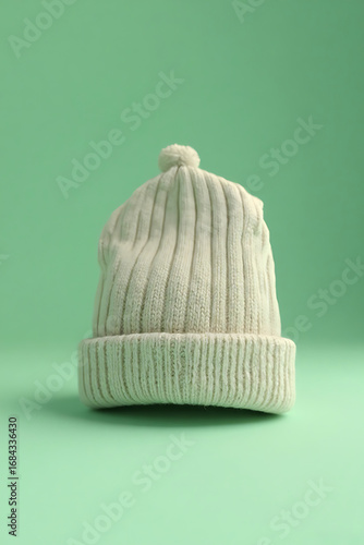 Cream White Knit Beanie Hat with Pom Pom on Light Green Background