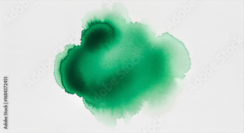 A green ink blot on a white background creating an abstract watercolor painting effect with soft edges