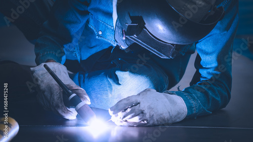 Photos A skilled worker is welding metal joints in an industrial workshop