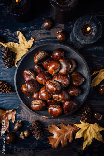 Organic sweet chestnuts with pumpkins on kitchen table, prepared for baking or cooking