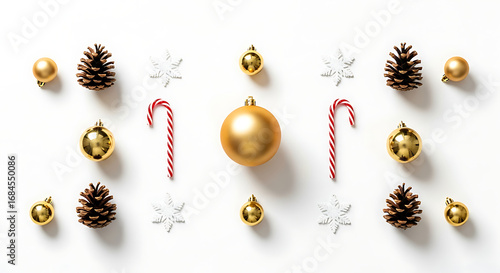 Flat lay of festive Christmas decorations including golden baubles, pine cones, candy canes, and snowflakes arranged on a white background.