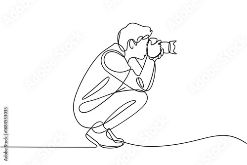 Photographer crouching low with camera in continuous line drawing