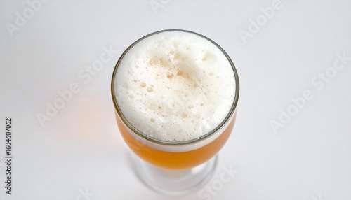 Overhead view of a pint of light-colored beer with a thick, creamy head.