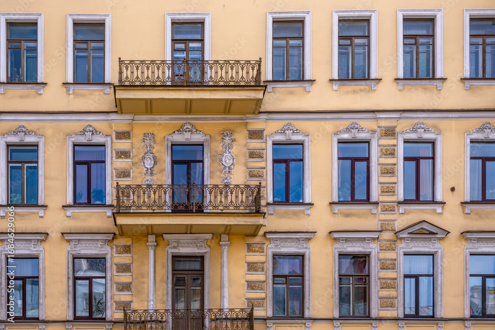 Fototapeta premium The wall of an old stone building with balconies.