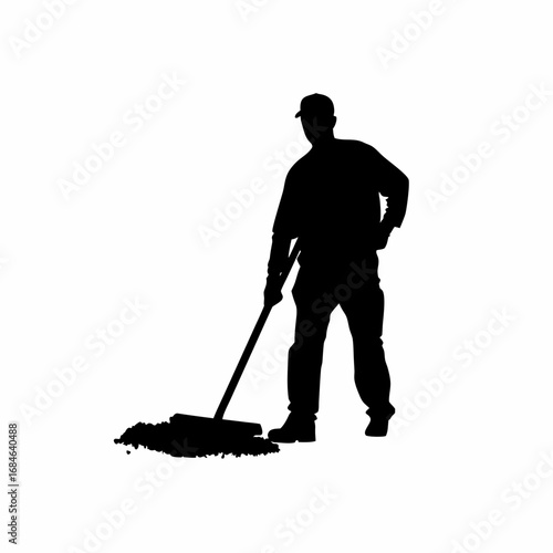 Silhouette of construction worker spreading concrete with a rake