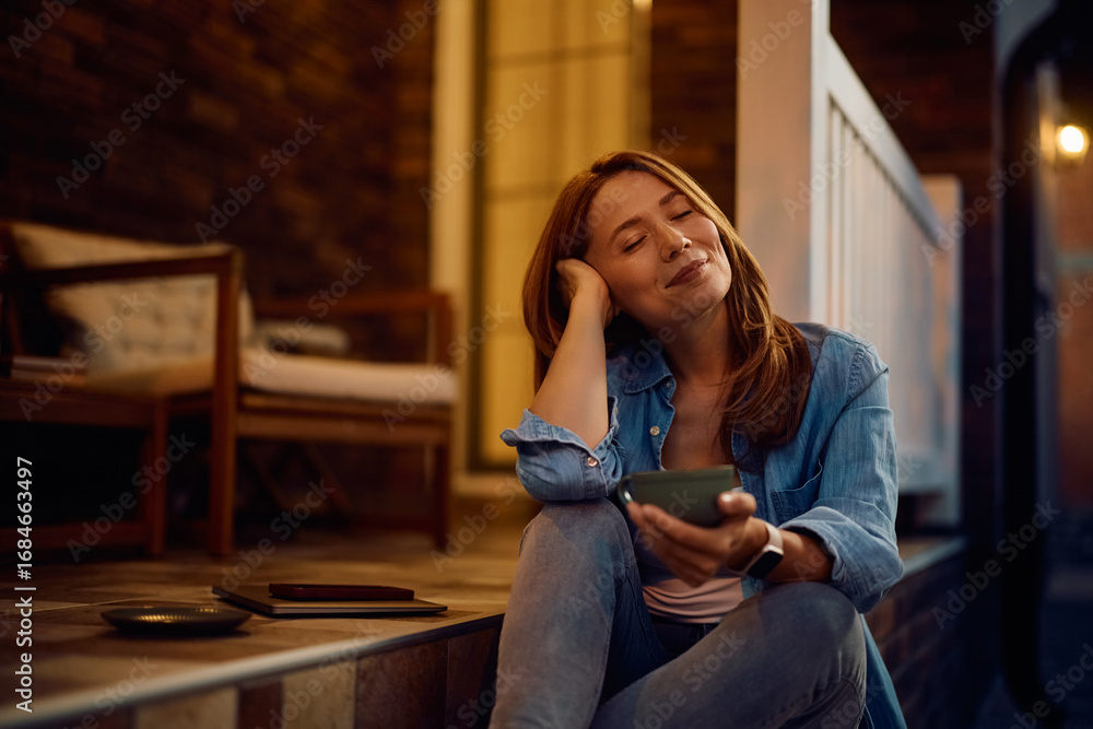 Obraz premium Smiling woman with eyes closed enjoying on porch at home.