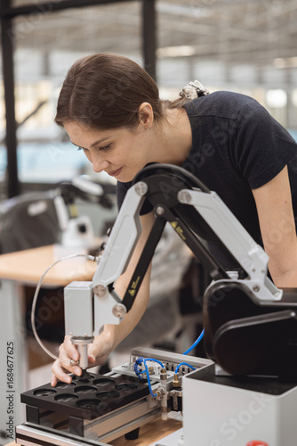 Engineer women learning education in Industrial Robotics program with robot arm simulation model in university engineering lab classroom.