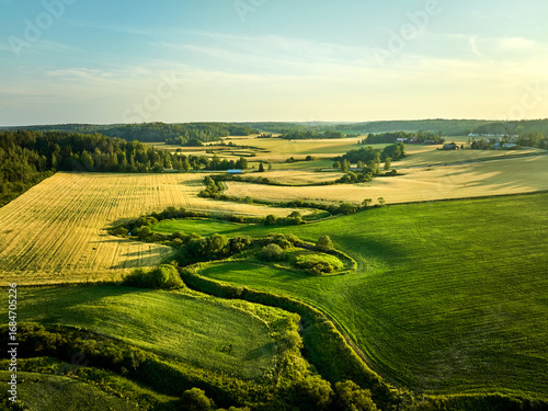 landscape with green field and blue sky and small river