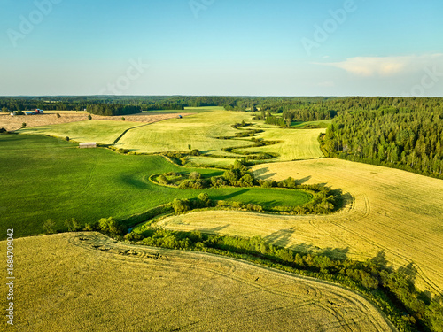 landscape with green field and blue sky and small river