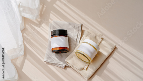 Wallpaper Mural Two glass jars with blank labels on folded linen cloths with dappled light container cream Torontodigital.ca