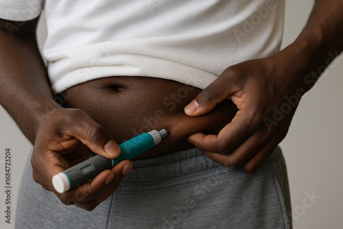 A faceless Black man self-injects a GLP-1 medication pen into his belly. Weight loss treatment using semaglutide