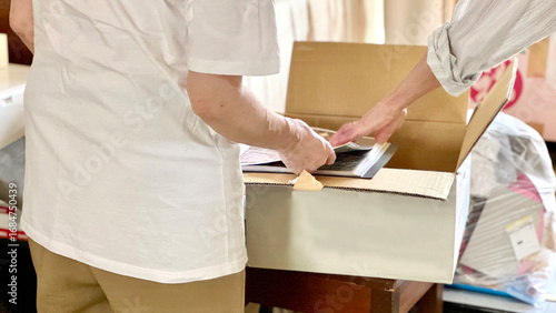 断捨離中にダンボール箱を開けて見る2人の手元