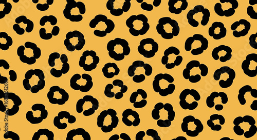 Close-up view of a repeating leopard print pattern on a mustard yellow background.