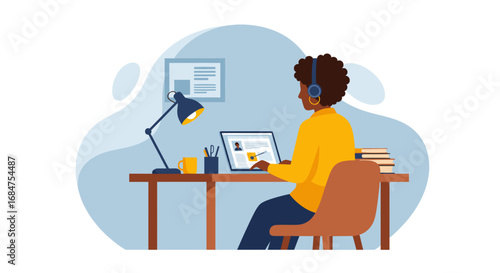 African American woman working remotely on her laptop with headphones, ideal for online education, business, or home office concepts.