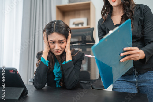In a tense office scene, an overwhelmed employee faces immense pressure and stress at work