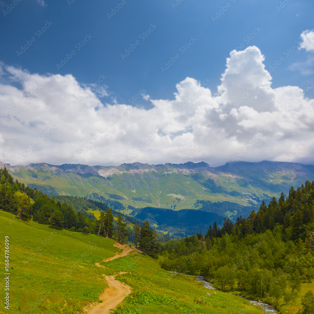 Fototapeta premium beautiful green mountain valley under blue cloudy sky