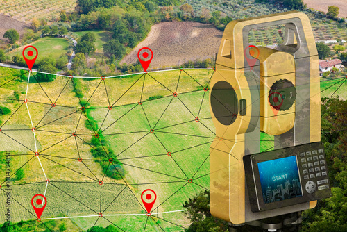 Foto SURVEYING EQUIPMENT AND DIGITAL MAP GRID OVER FARMLAND TERRAIN -