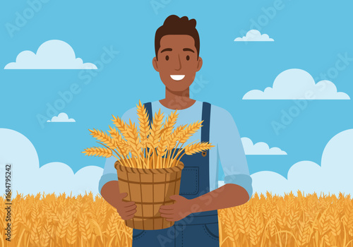 A farmer smiles holding a bucket of wheat in a field under a partly cloudy sky