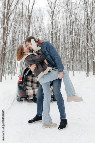 A Romantic Winter Kiss A Young Couple Embracing in a Gorgeous, Picturesque Snowy Landscape Right Next to Their Car, Sharing Warmth and Love While Surrounded by the Chilly Winter Air