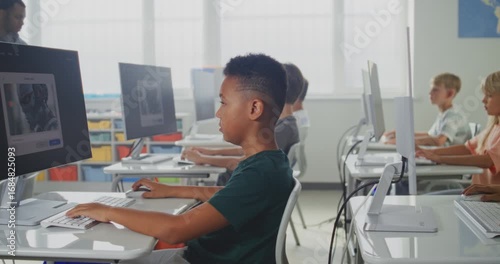 Elementary School Children Using Computers, Creating Illustrations in AI Image Generator. African American Teacher Teaching Young Boys and Girls During Digital Art Lesson. STEM Education. Dolly Shot.