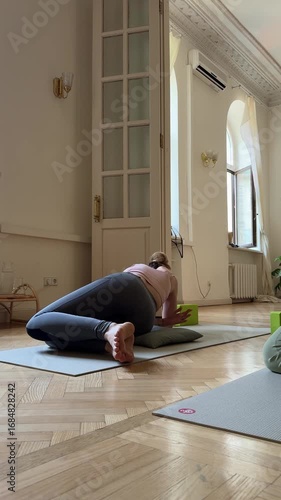 A person is practicing yoga on a mat in a bright room filled with natural light. retro room in Provence style