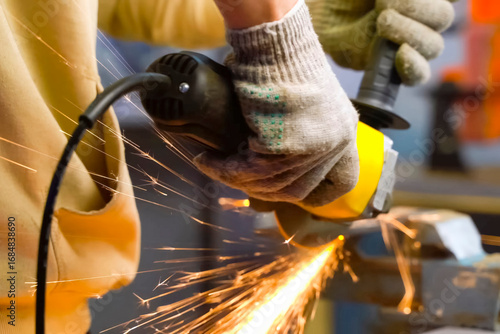 Grinding throwing knife in a vise using an angle grinder.