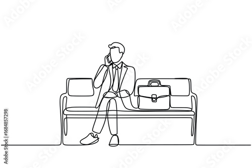 Businessman on phone sitting on sofa with briefcase