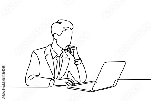 Businessman in suit working on laptop with hand on chin