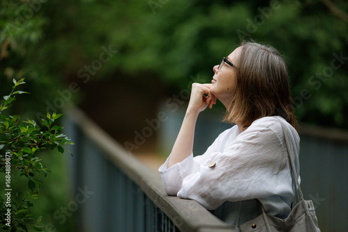 Woman enjoying a peaceful moment while looking up at the greenery in a serene outdoor setting