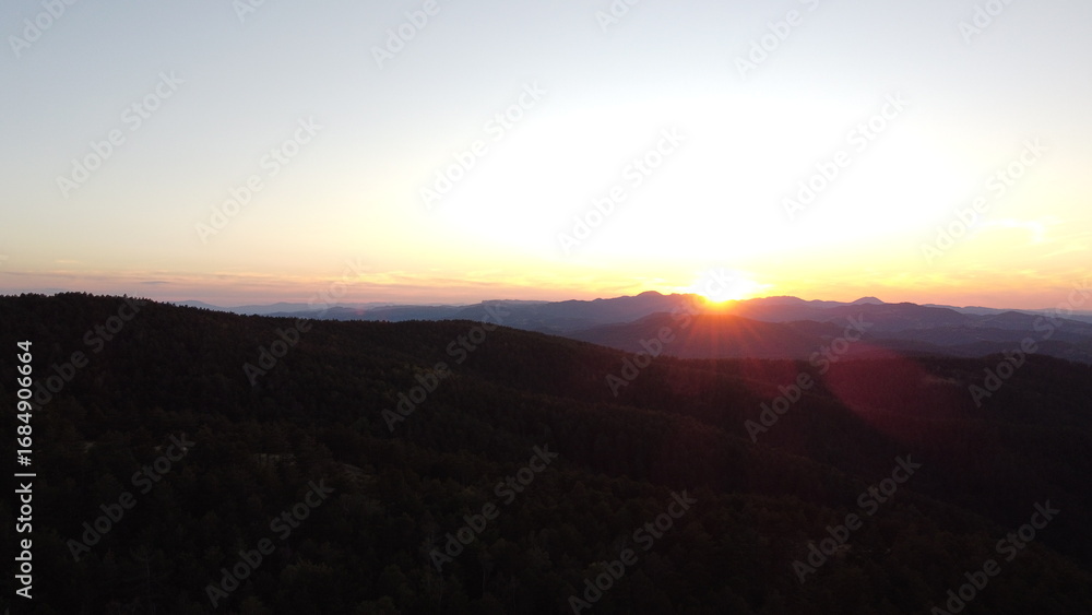 Obraz premium Sunset Over Mountain Range and Forest – Aerial View Landscape 