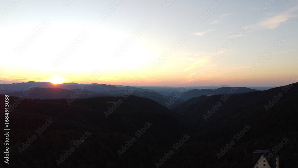 Obraz premium Sunset Over Mountain Range and Forest – Aerial View Landscape 