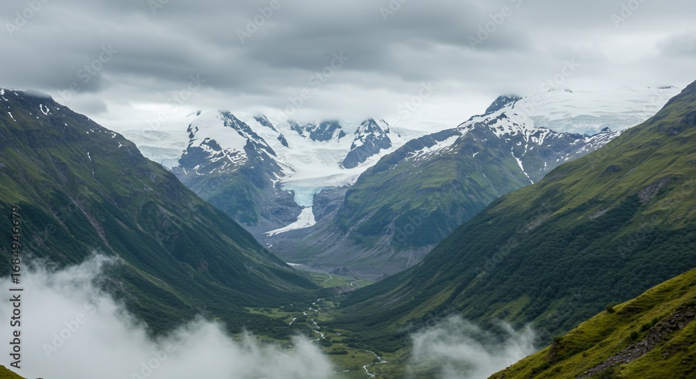 Naklejka premium Breathtaking glacial valley landscape snow capped peaks green mountains cloud cover aerial view
