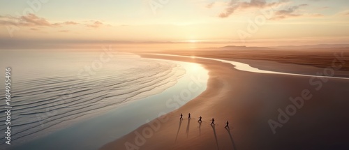 People walk on a serene beach at sunrise, enjoying a peaceful morning wellness experience by the calm ocean waves and soft light.