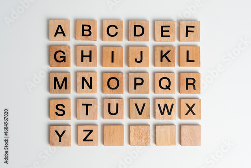 Alphabet letters on wooden scrabble pieces, isolated on white.