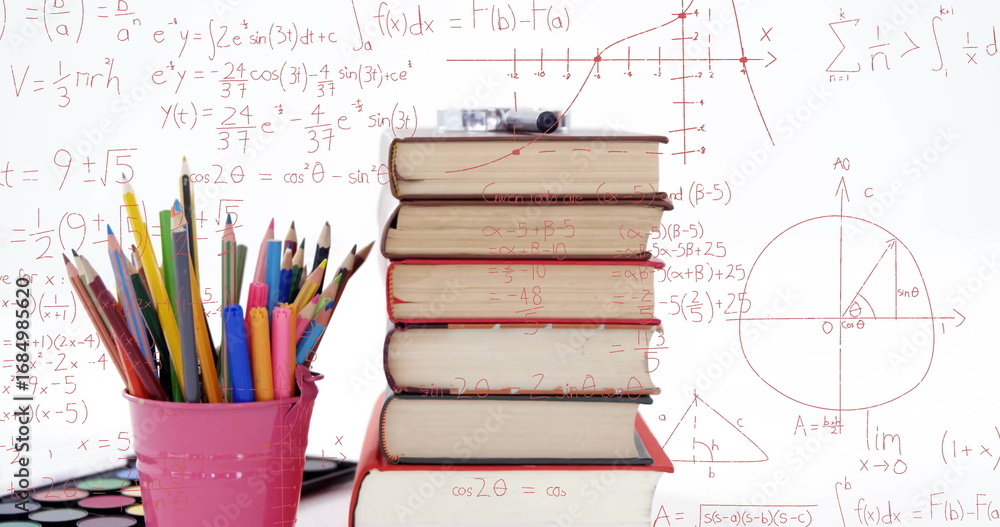 Naklejka premium Stack of six hardcover books leaning on desk in studio, with colored pencils and watercolor palette