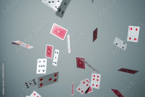 Playing cards falling and scattering in mid air against a gray background