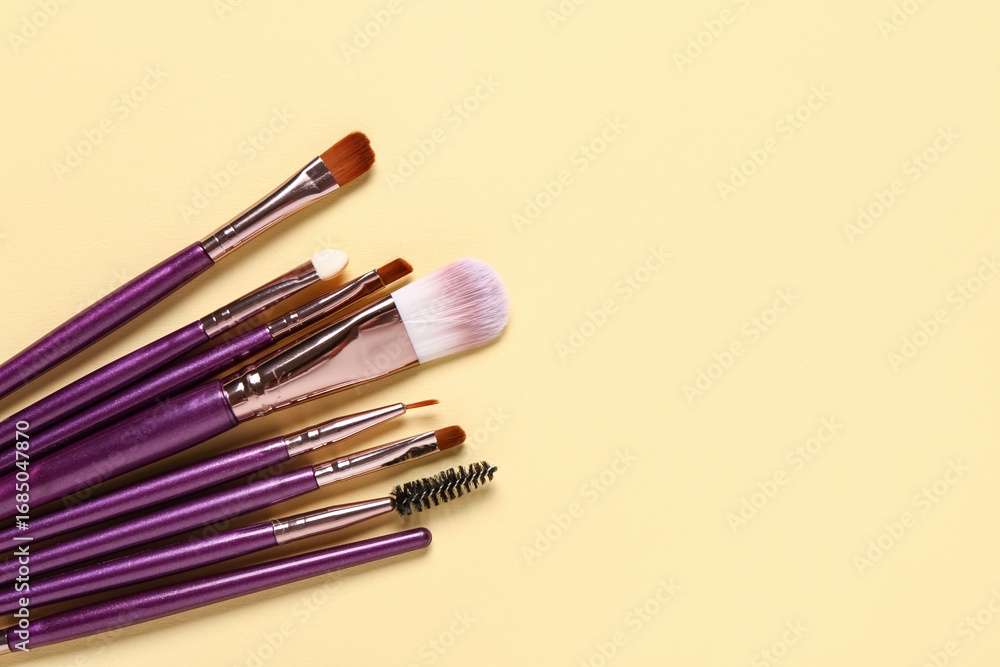 Obraz premium Makeup brushes on yellow background