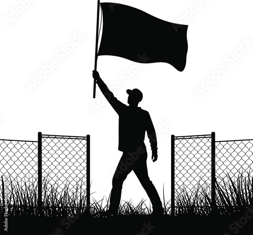 Silhouette of a person holding a black flag standing between barbed wire fences