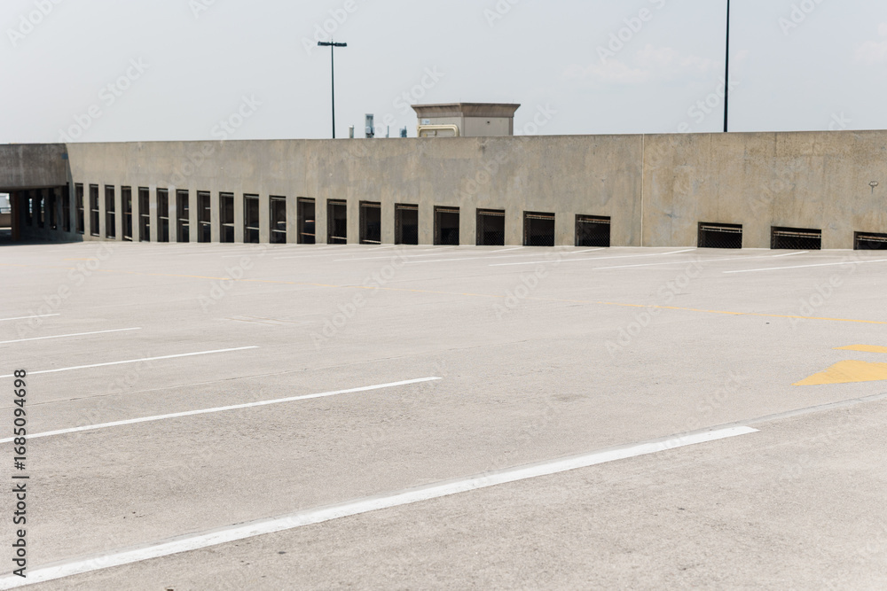 Obraz premium Open rooftop parking deck with empty spaces.
