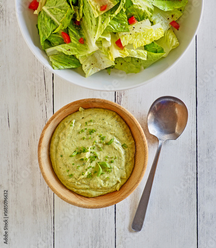bowl of green goddess salad dressing made with avocado, garlic, basil, cilantro, and thyme