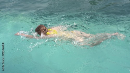 Wallpaper Mural Red-haired girl in yellow swimsuit swimming freestyle in a blue swimming pool, summer holiday video. Torontodigital.ca