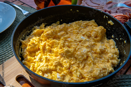 aromatyczna, świeżo przygotowana jajecznica na czarnej patelni