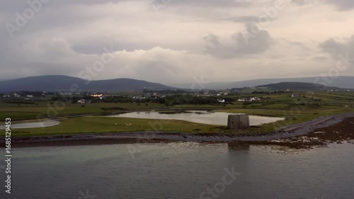 Ascending aerial shot at twilight revealing County Clare’s dramatic coastline, with Aughinish Martello Tower in the foreground