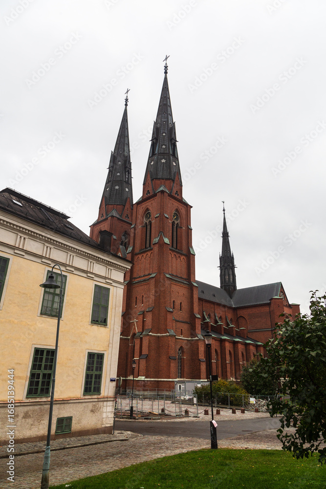 Fototapeta premium Uppsala, Sweden - 2 October 2022: Uppsala Cathedral in autumn with grey sky