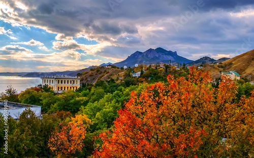 Scenic autumn landscape with vibrant foliage and mountains by water  