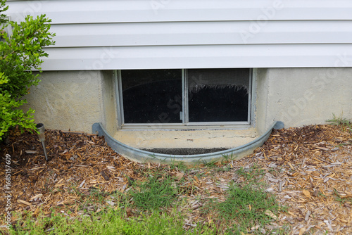 A view of a basement window  well of a residential home